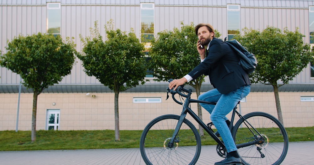 Mann der auf seinem Fahrrad telefoniert