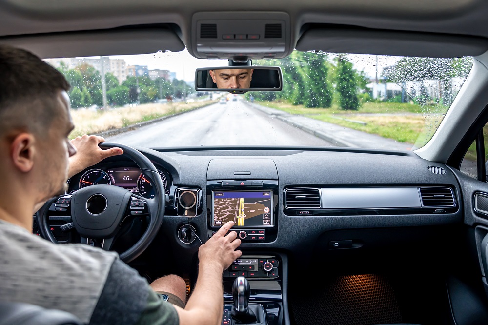 Mann der die Navigation in seinem Auto per Touchscreen bedient