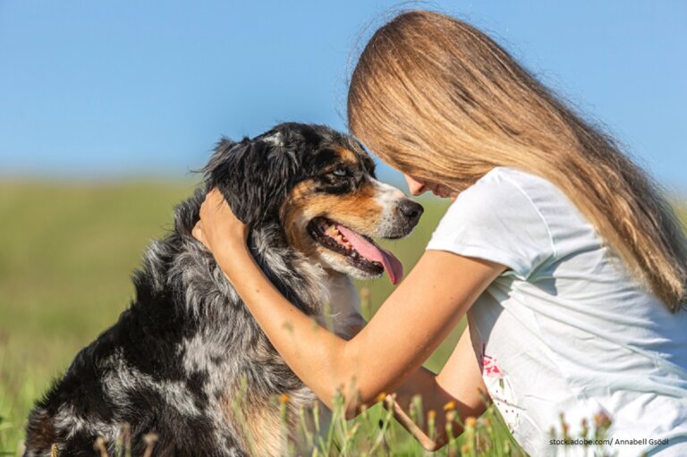 Glückliche Frau die ihren Hund streichelt