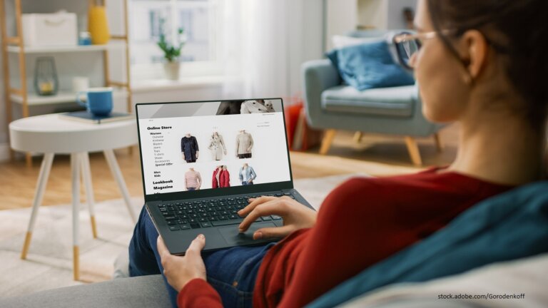 Junge Frau, die auf ihrem Laptop Online shoppt