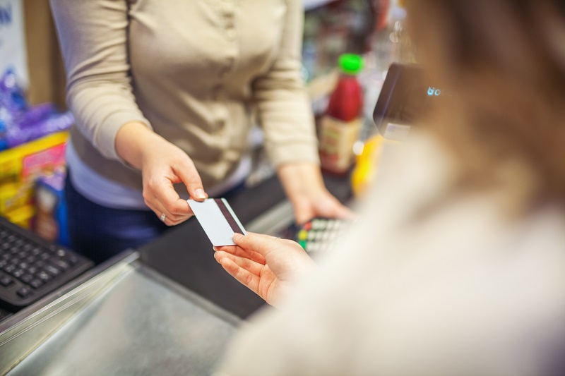 Frau an der Supermarktkasse, die mit ihrer Karte bezahlt