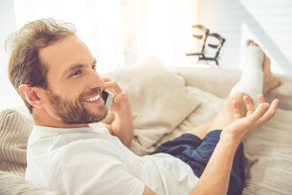 Mann auf Sofa mit gebrochenem Bein