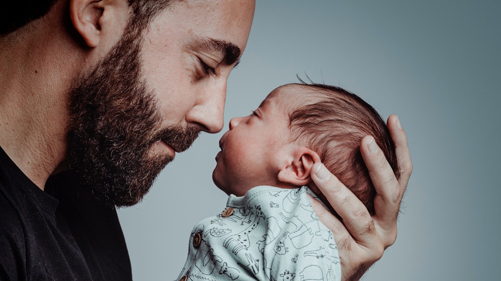 Vater der sein Baby im Arm hält