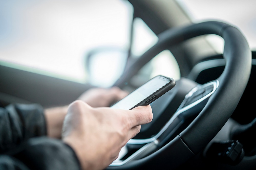 Handy am Steuer während der Autofahrt