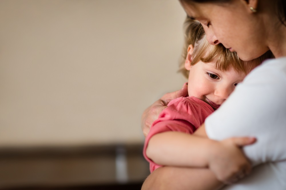 Mutter umarmt ihre kleine Tochter