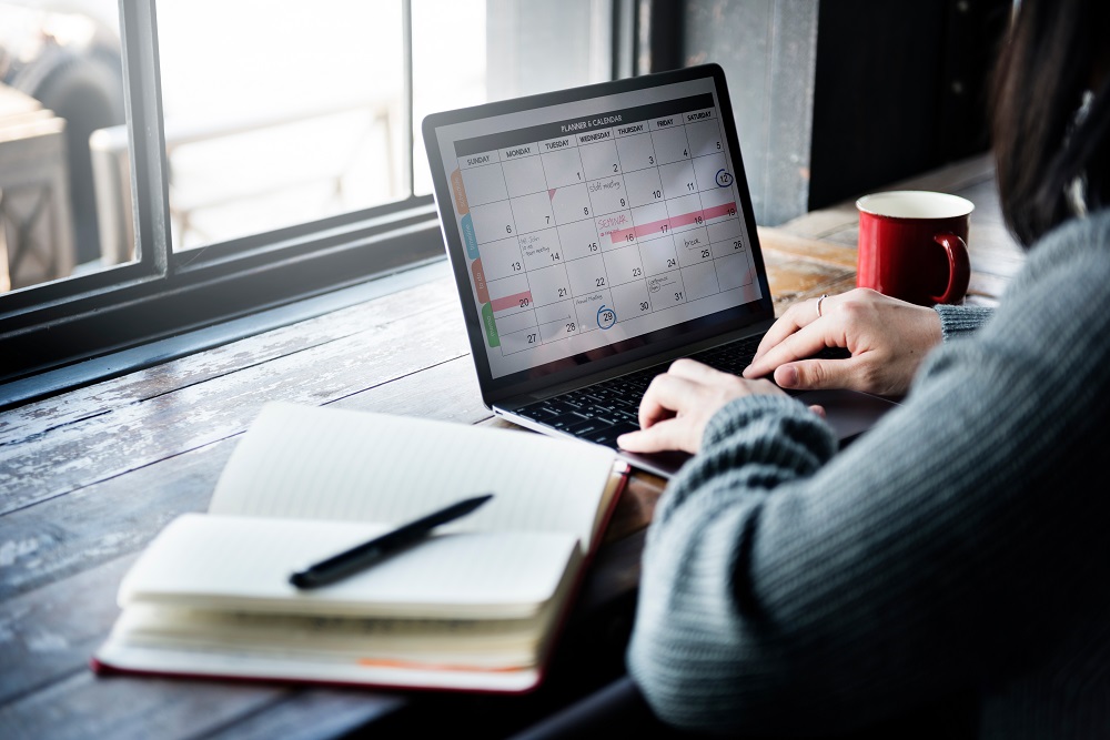 Frau mit Kalender am Laptop