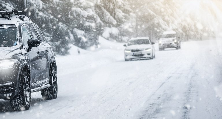 Autofahren im Winter auf einer zugeschneiten Straße