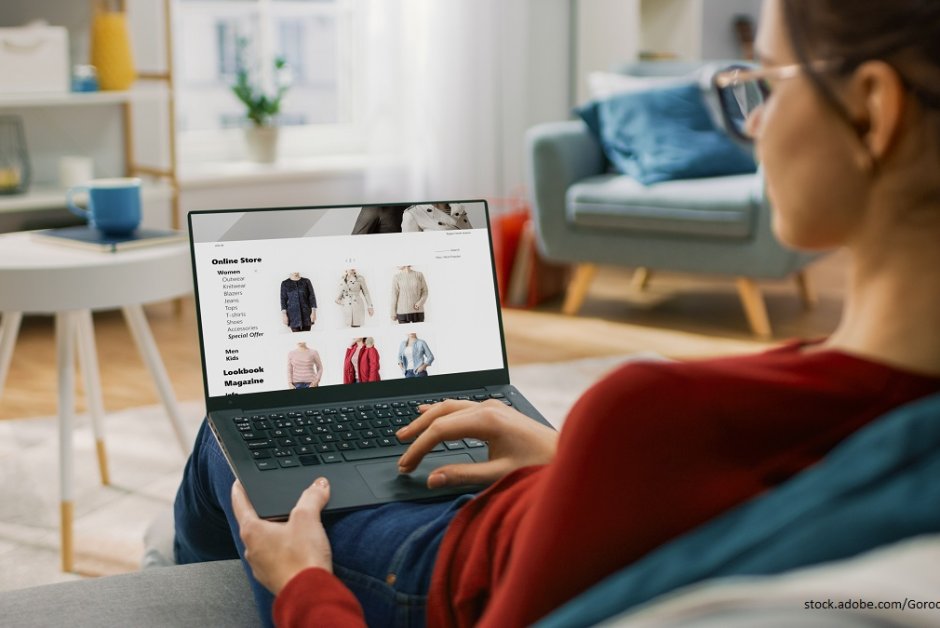 Junge Frau, die auf ihrem Laptop Online shoppt